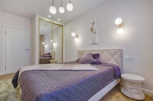 Decoração de quarto de casal 2025 com cabeceira estofada e luminárias modernas.