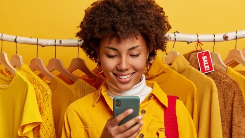 pesquisando no celular ofertas de roupas