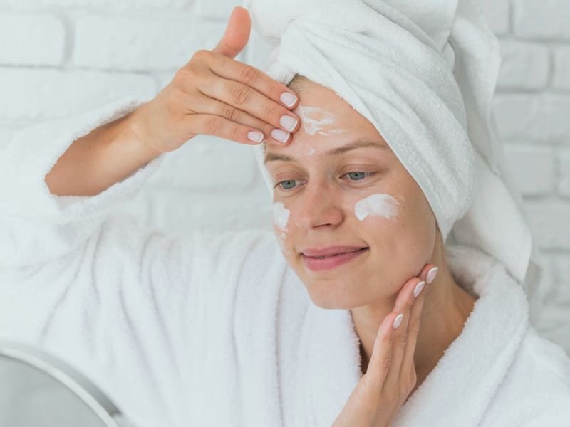 mulher passando hidratante no rosto